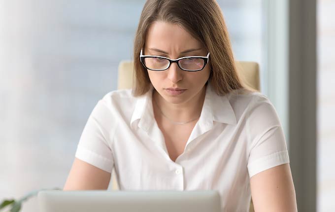 woman with glasses concentrating at computer